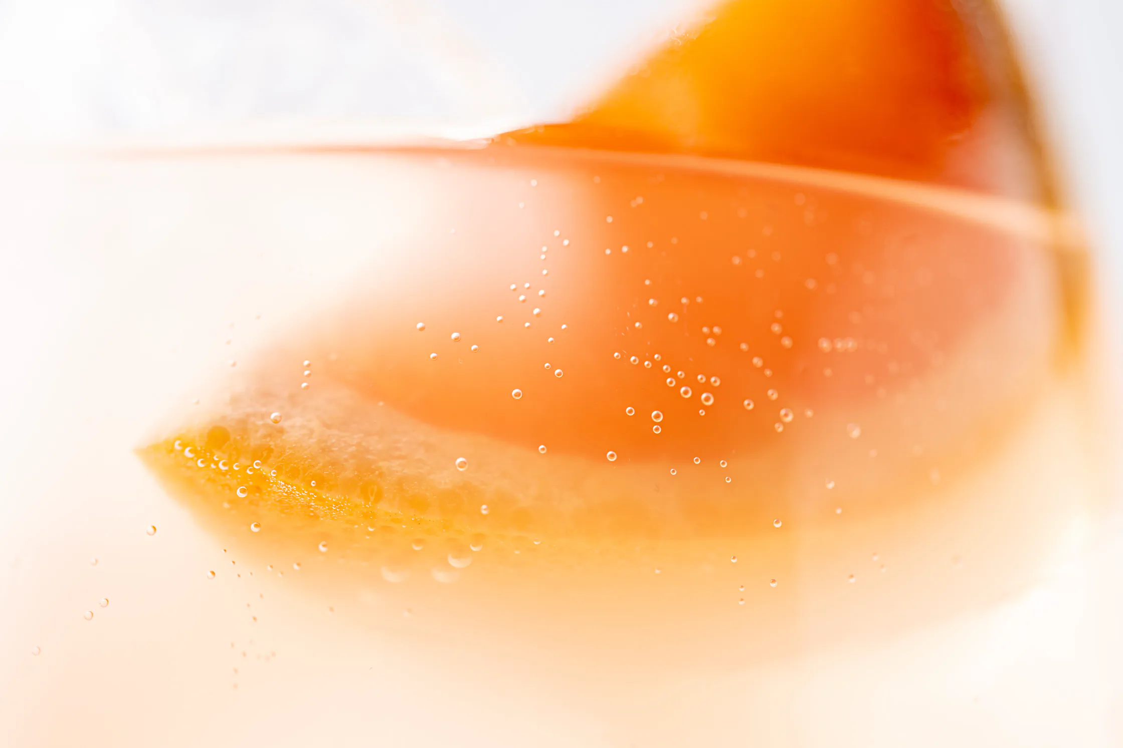 Abstract macro close-up of an orange sparkling drink with bubbles