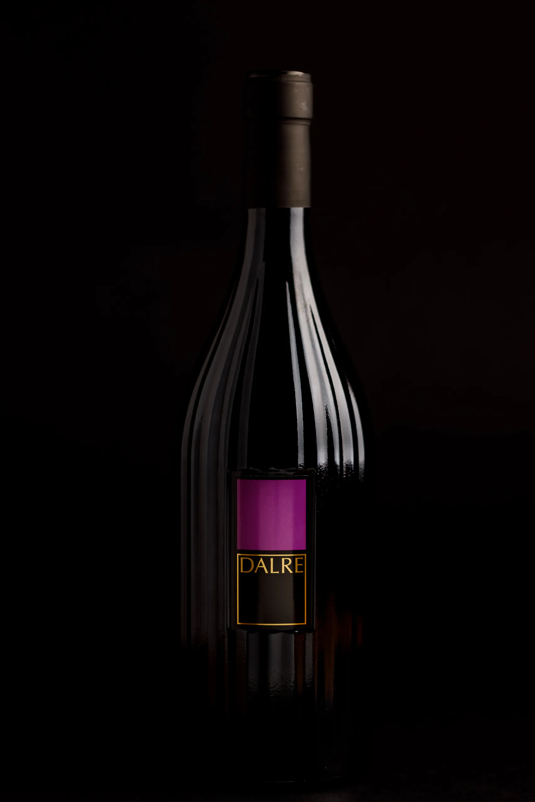 Dark bottle of Feudi di San Gregorio wine of sparkling wine against a black background