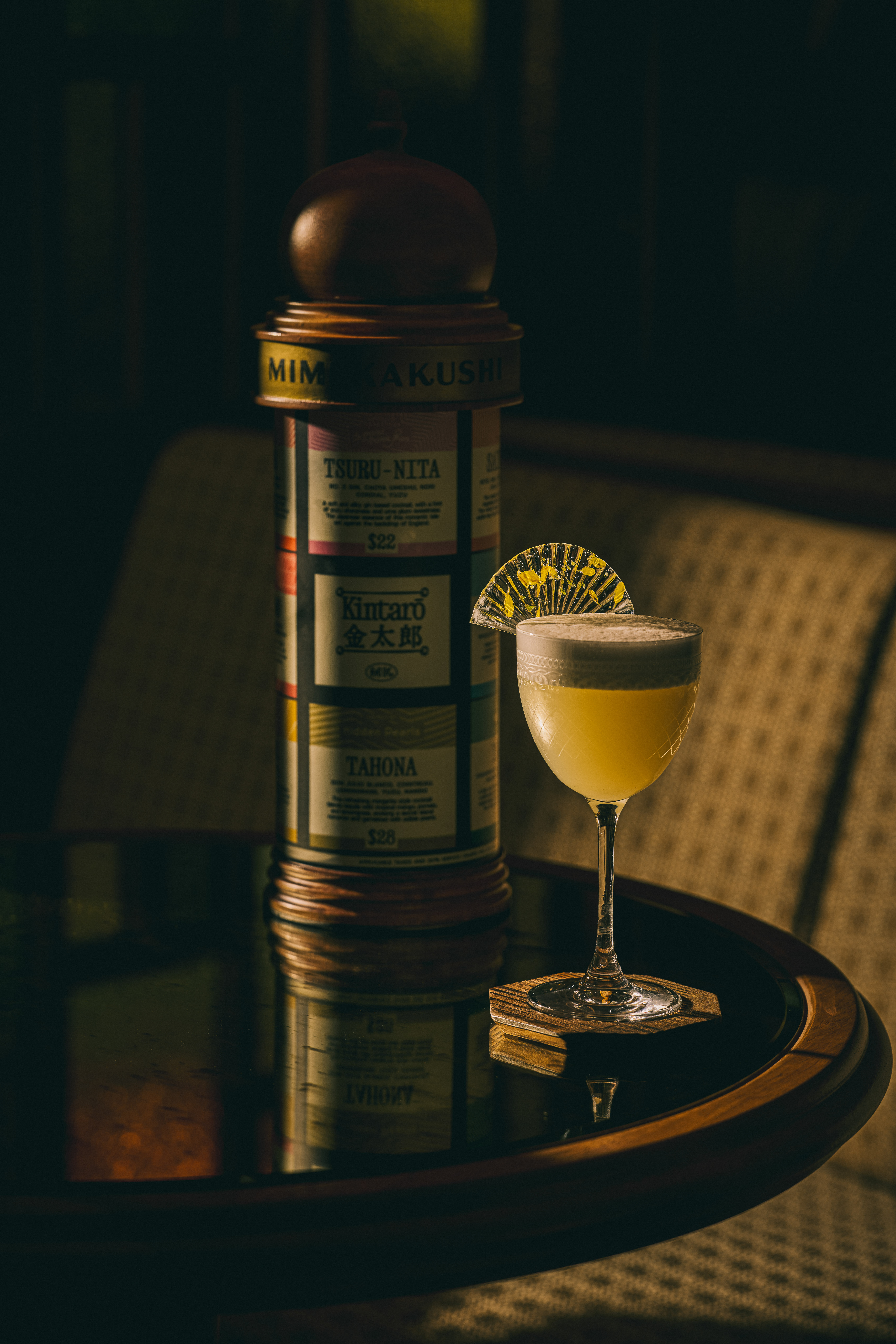 Elegant cocktail beside a vintage tin canister in a moody bar — Delano, Miami