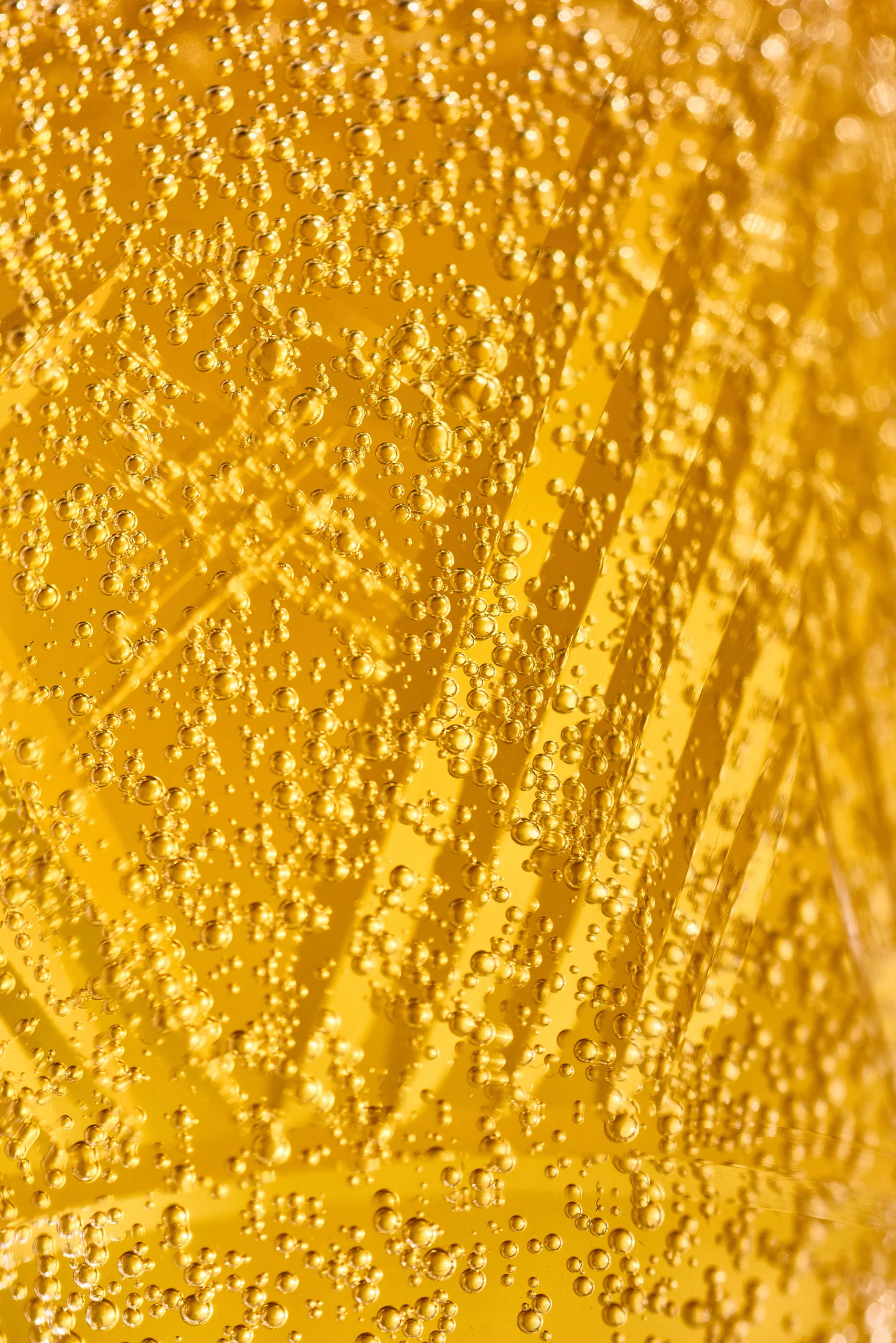 Abstract macro close-up of golden effervescent liquid — kombucha