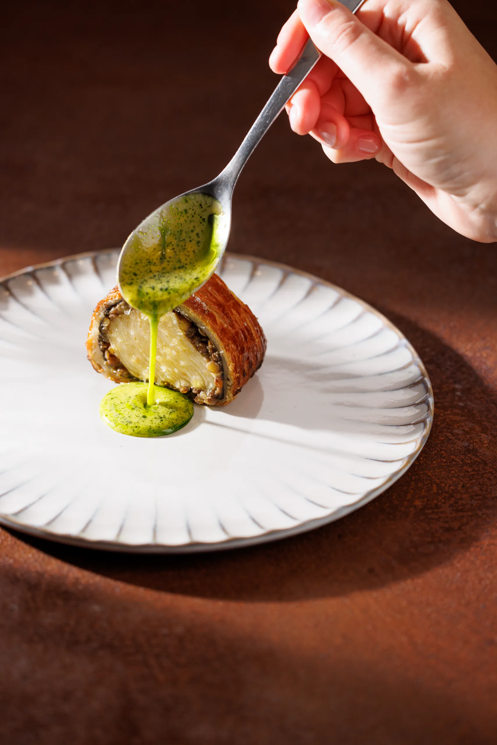 Chef spooning green sauce over a pastry-wrapped dish - Sintesi, Ariccia, Italy