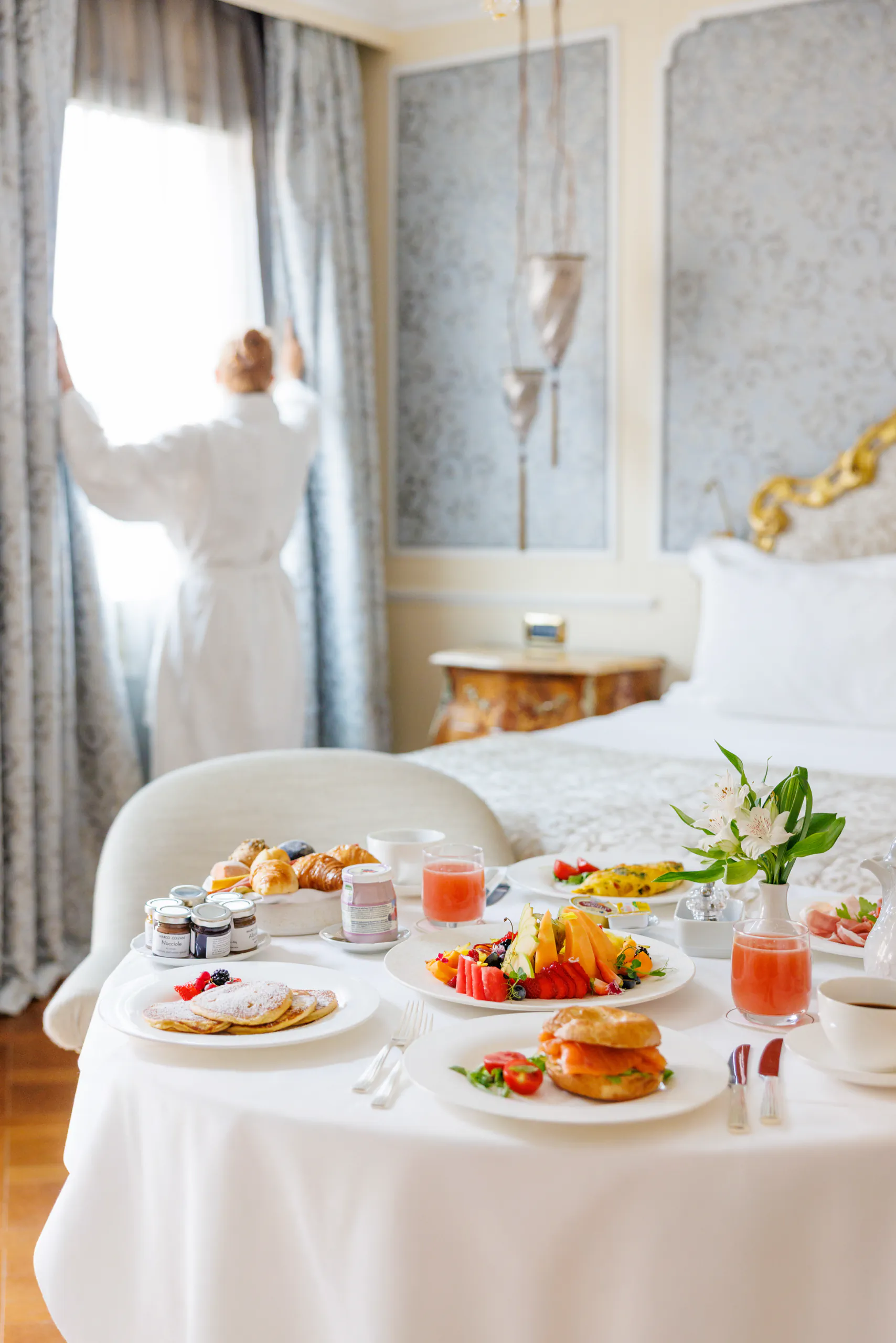 In-room breakfast spread with a guest by the window - Baglioni Luna, Venice, Italy