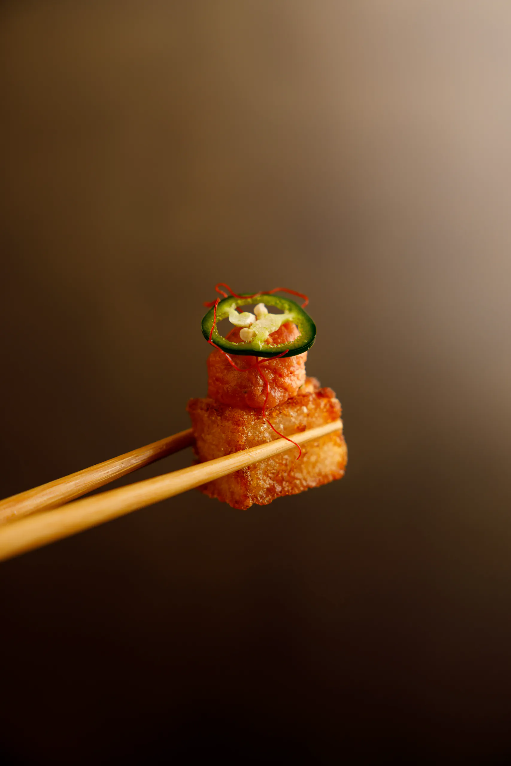 Fried sushi piece held with chopsticks