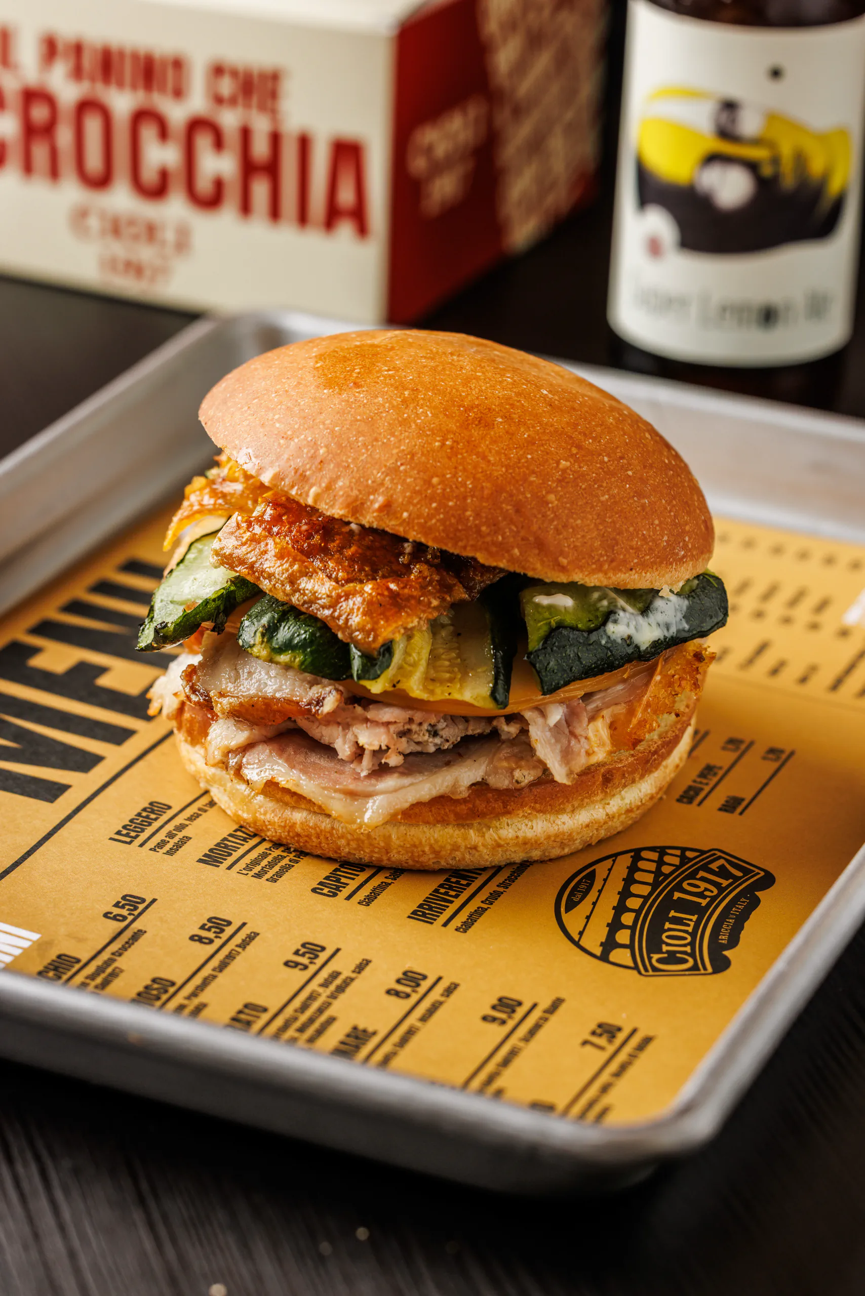Porchetta sandwich on a metal tray with a beer - Cioli, Rome, Italy