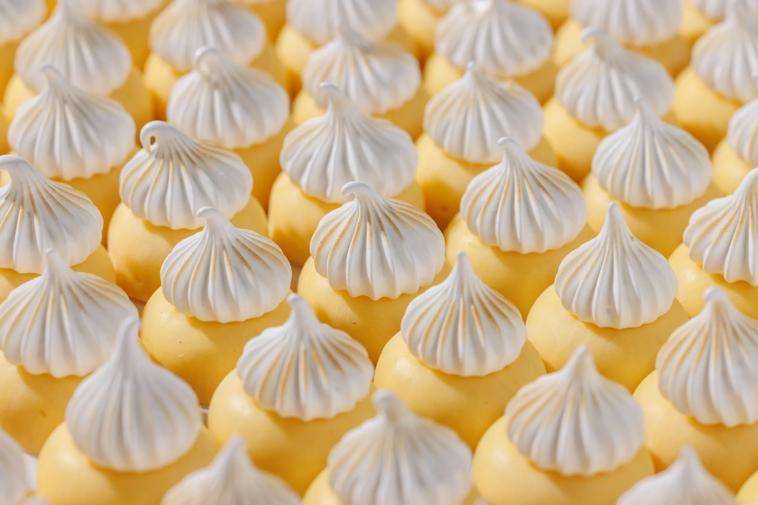 Piped meringue peaks over lemon curd, close-up