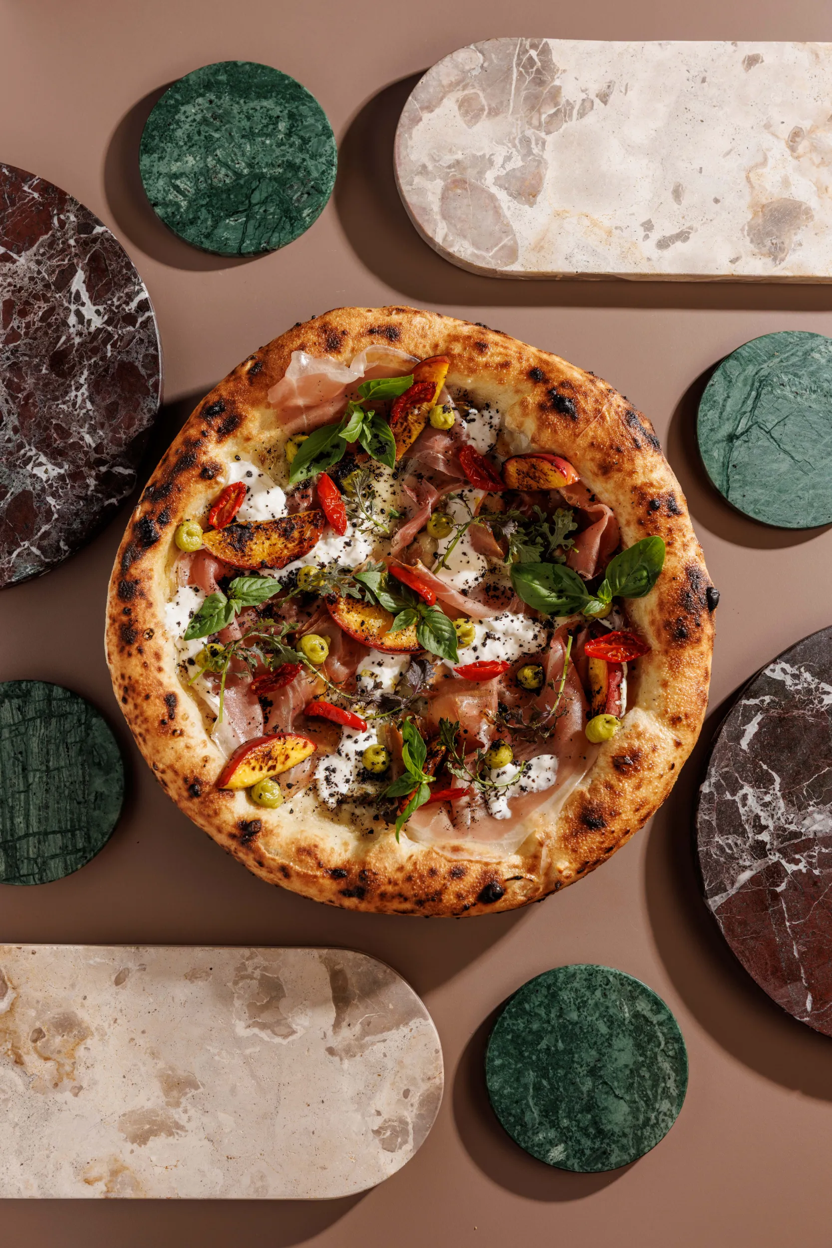 Pizza with prosciutto and tomatoes among marble slabs, seen from above - SEU Pizza, Rome, Italy