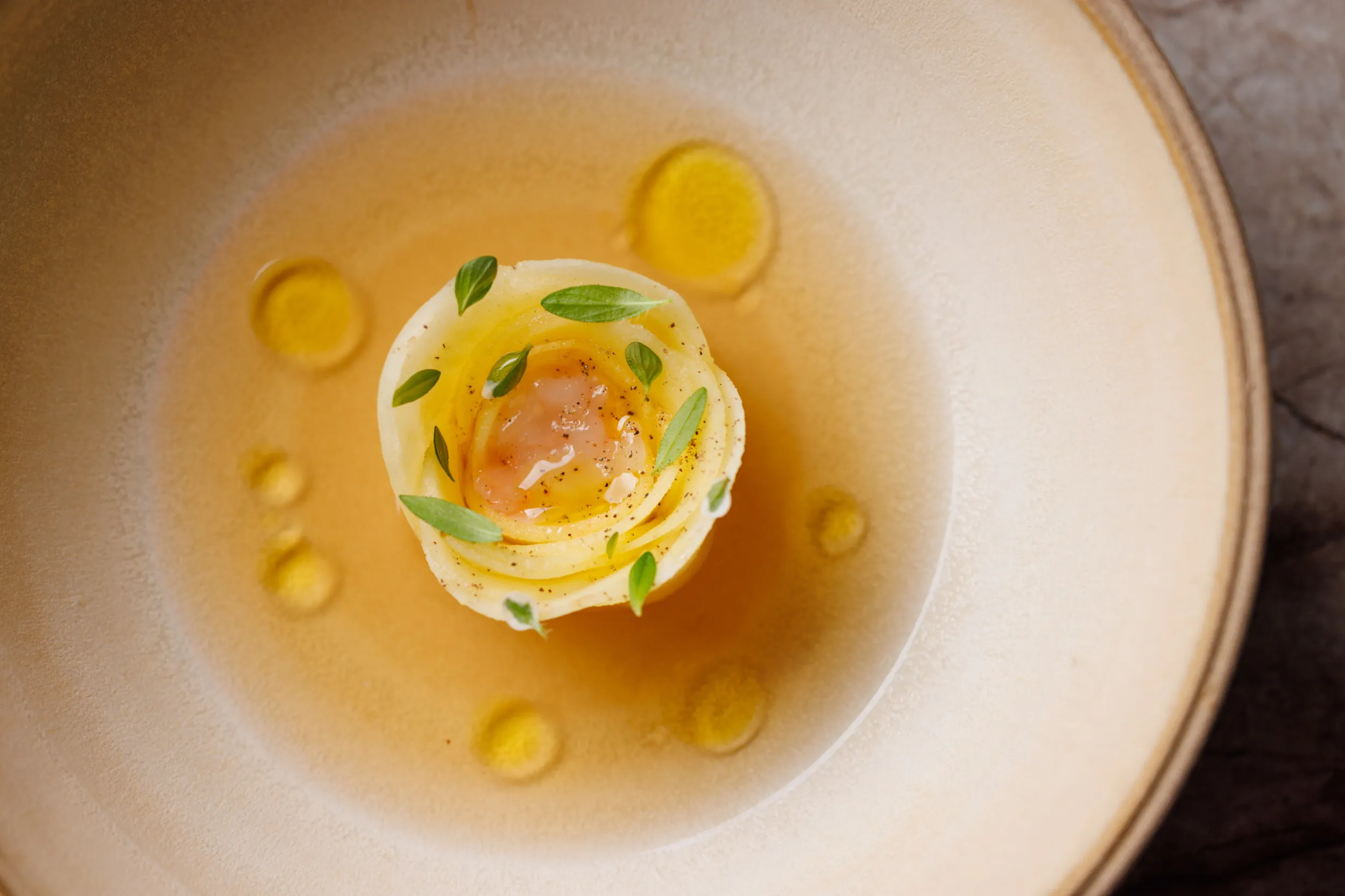 Egg-yolk raviolo in golden broth with herbs - Sintesi, Ariccia, Italy