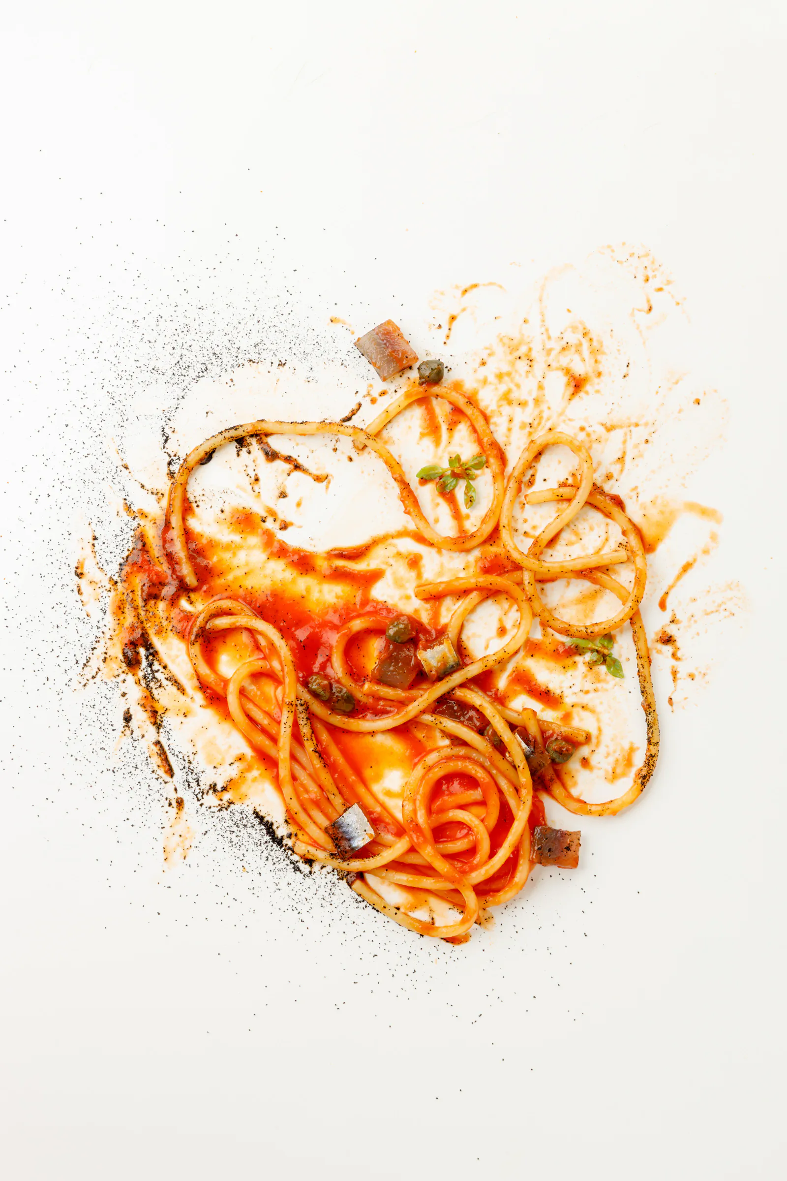 Spaghetti with tomato sauce artfully splayed on white - Marco Martini, Rome, Italy