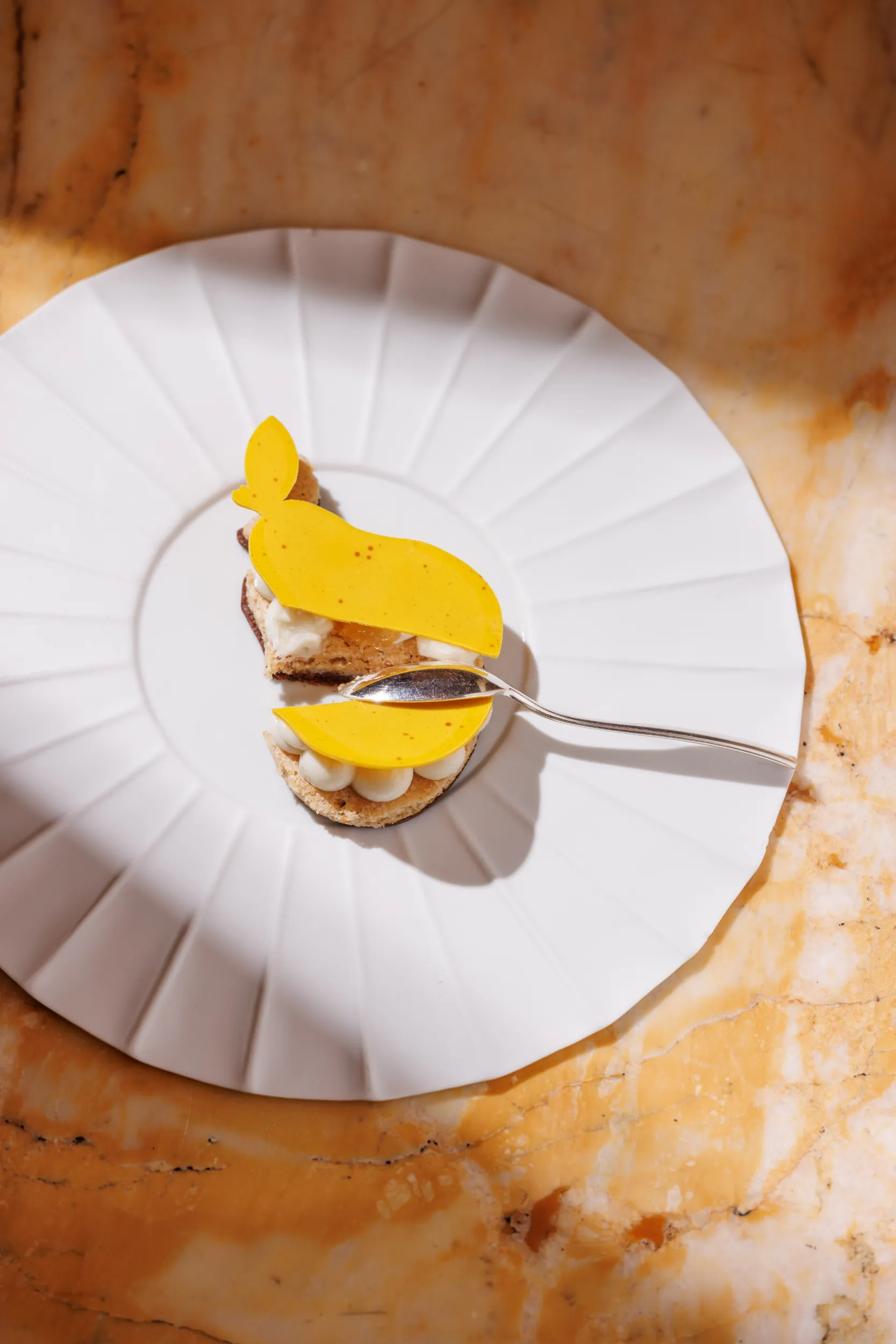 Plated dessert with a mango tuile on a pleated plate - Principe di Savoia, Milan, Italy