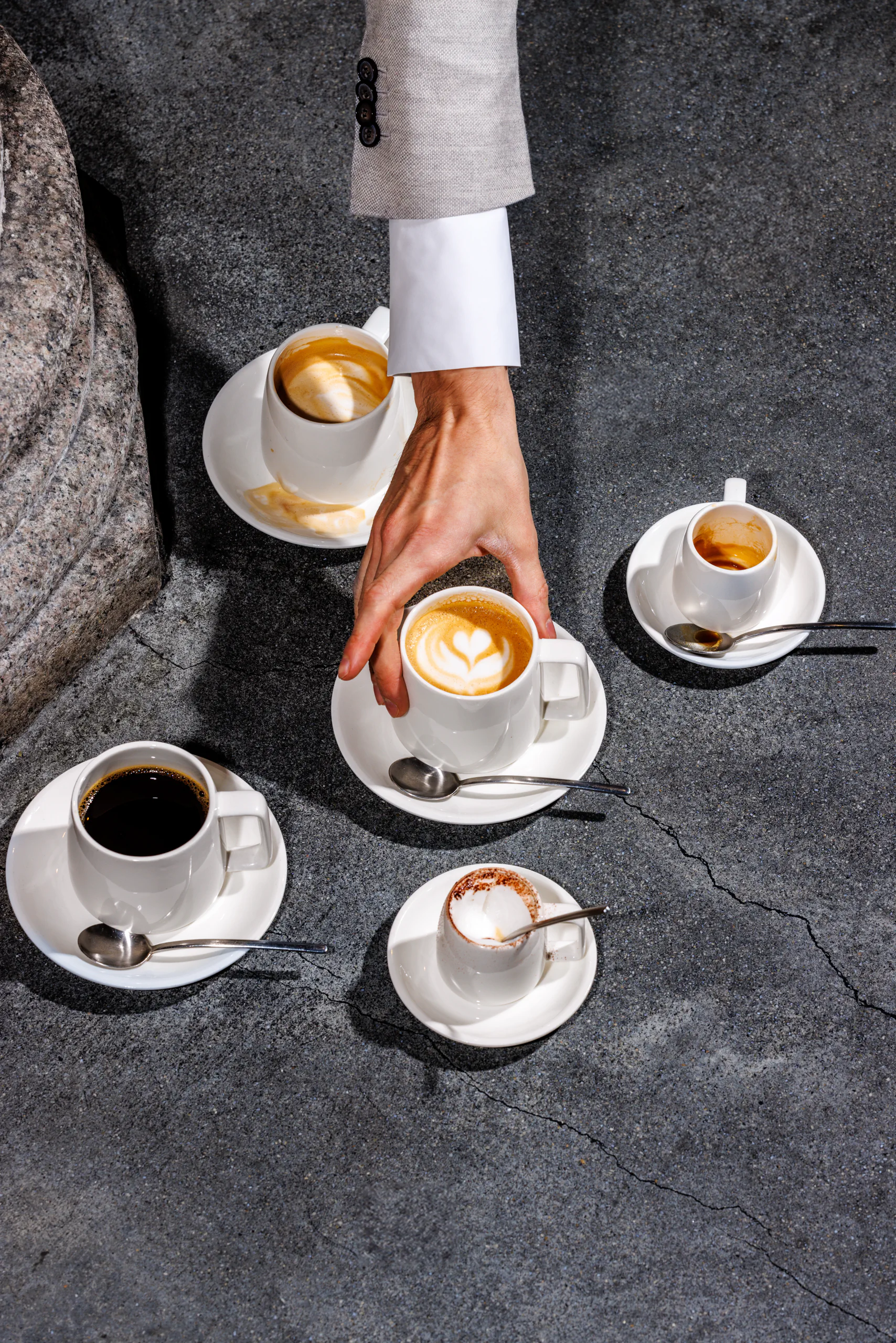 Cups of espresso and cappuccino arranged on a stone floor - Straf, Milan, Italy