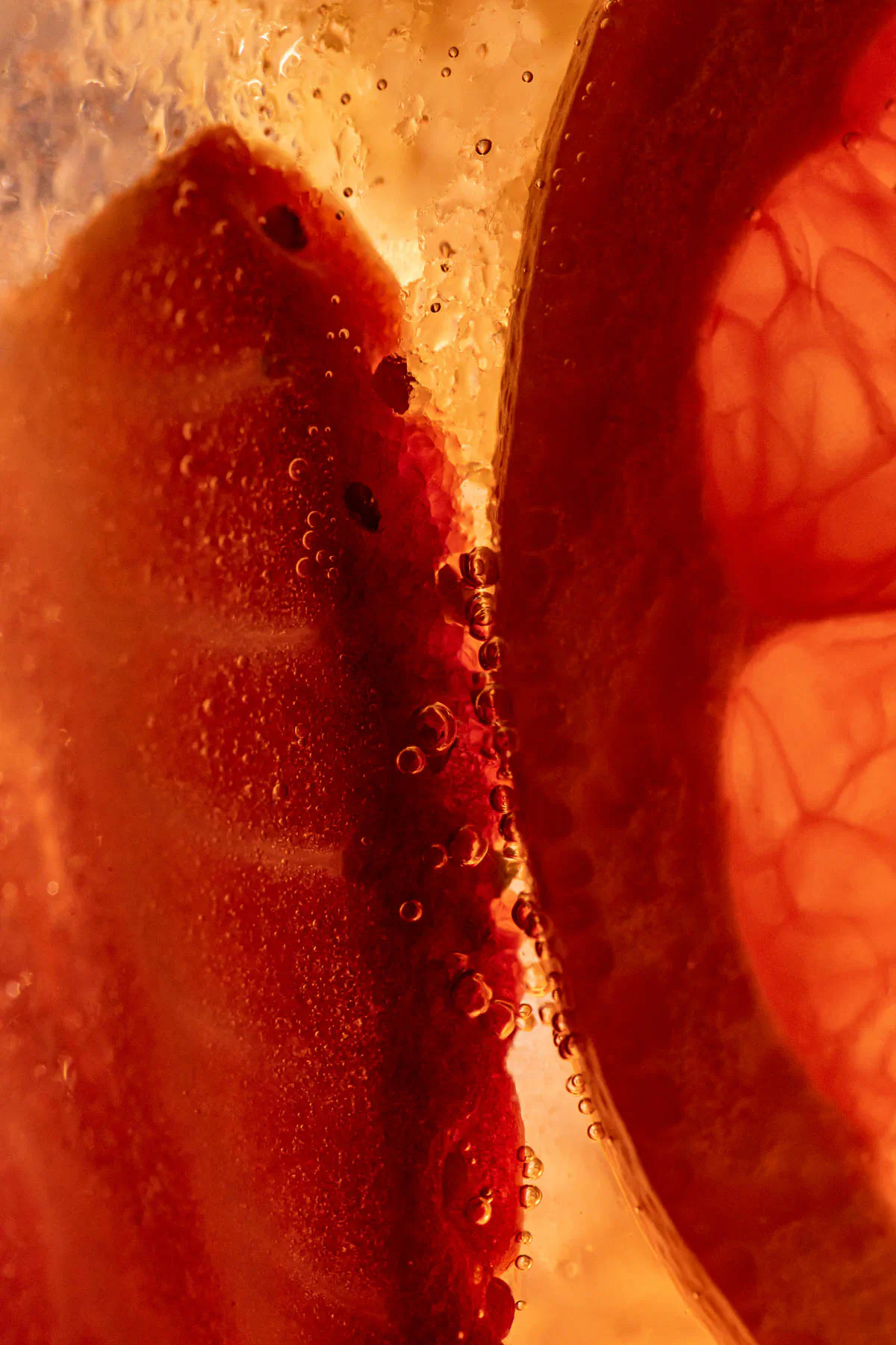 Abstract macro close-up of a red drink with a strawberry and bubbles