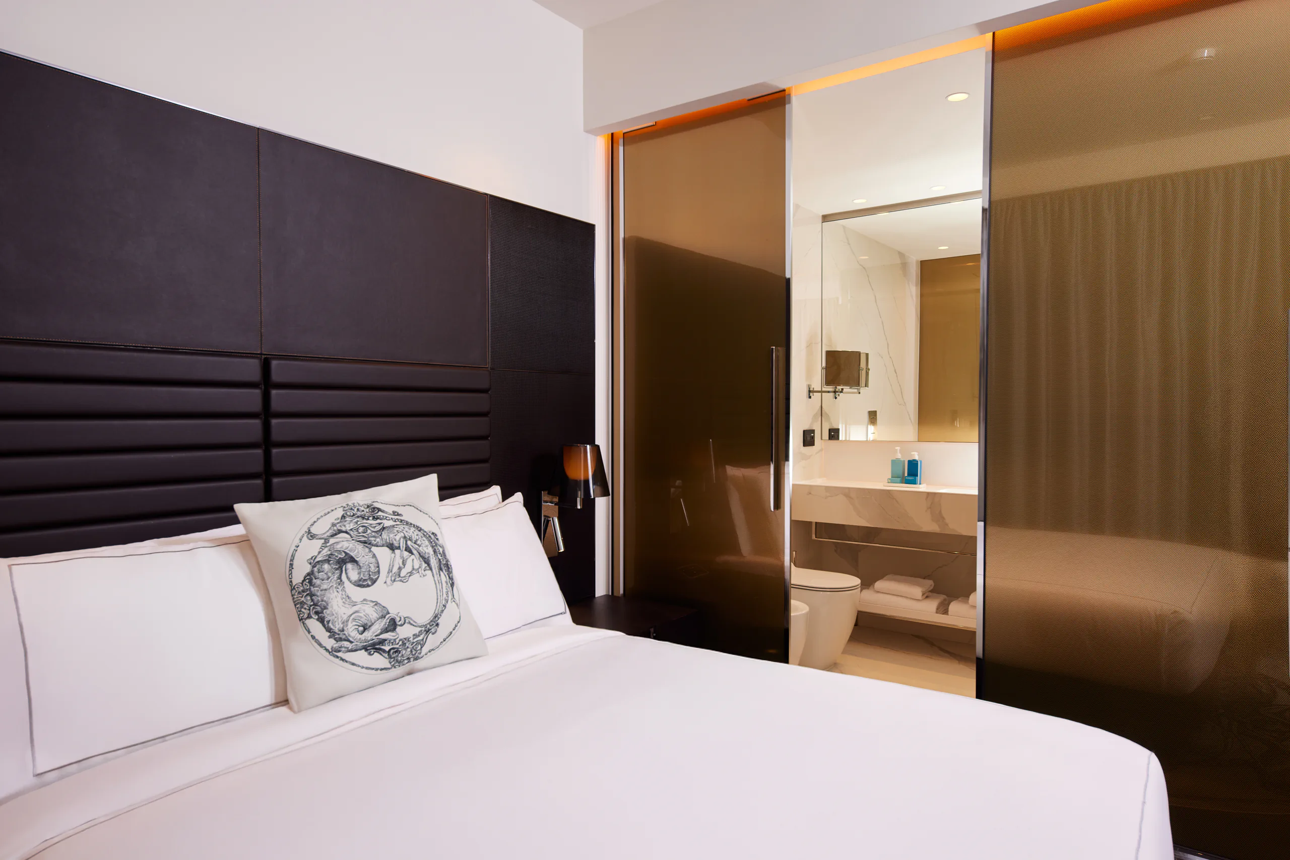 Hotel room with a bed, dark headboard and an open en-suite bathroom — art'otel, Rome