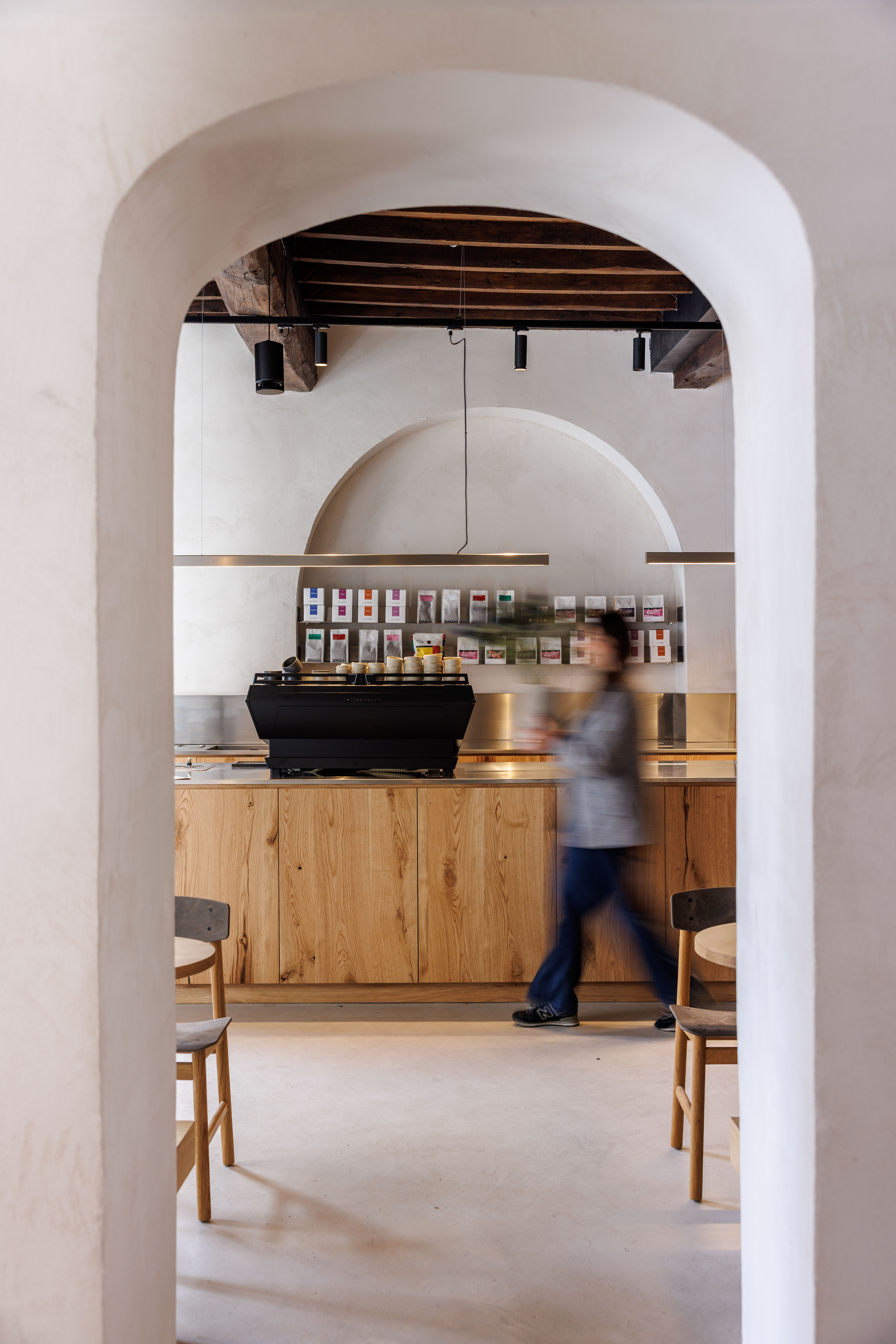 Bright arched room with a counter and a person walking