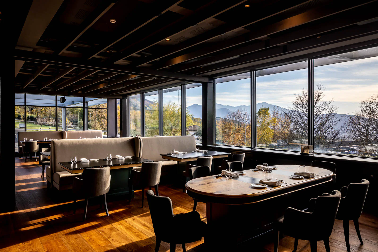 Restaurant dining room with large windows overlooking a mountain landscape