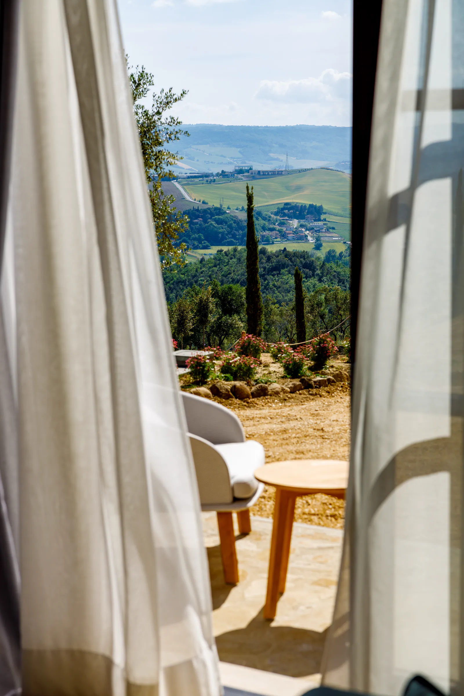 Terrace with a billowing white curtain, an armchair and a countryside view