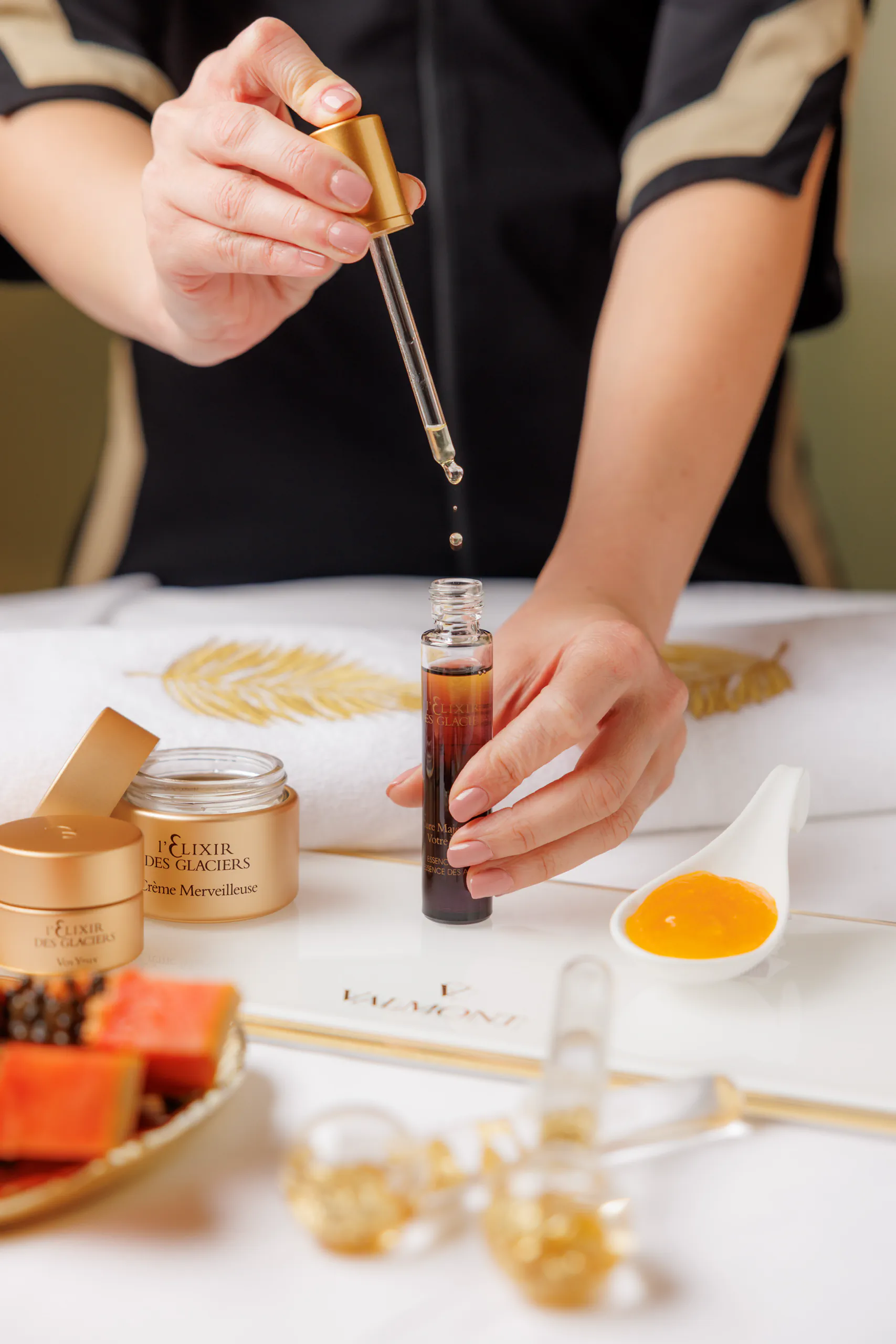 Hands preparing a dish with a dropper and small bowls of ingredients