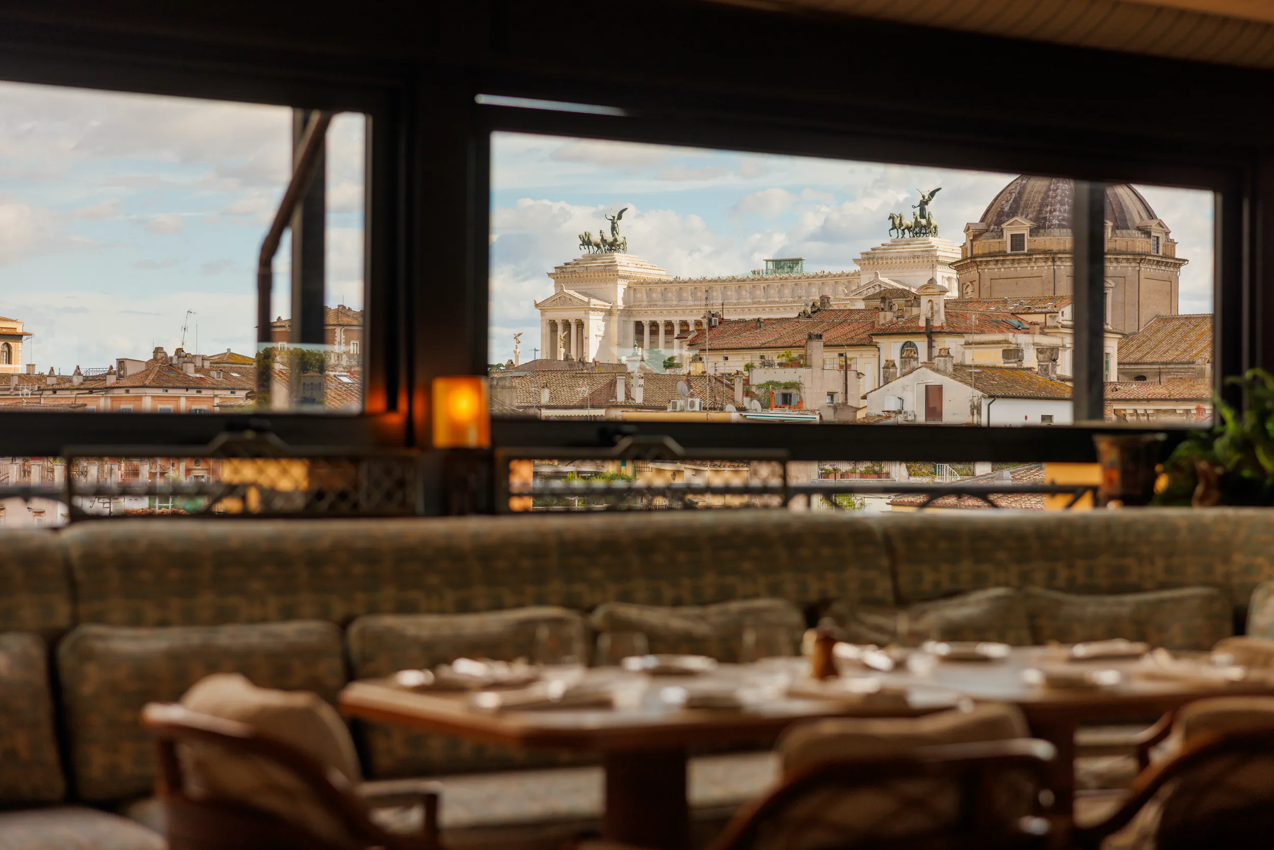 Elegant restaurant interior with panoramic windows overlooking Rome's rooftops