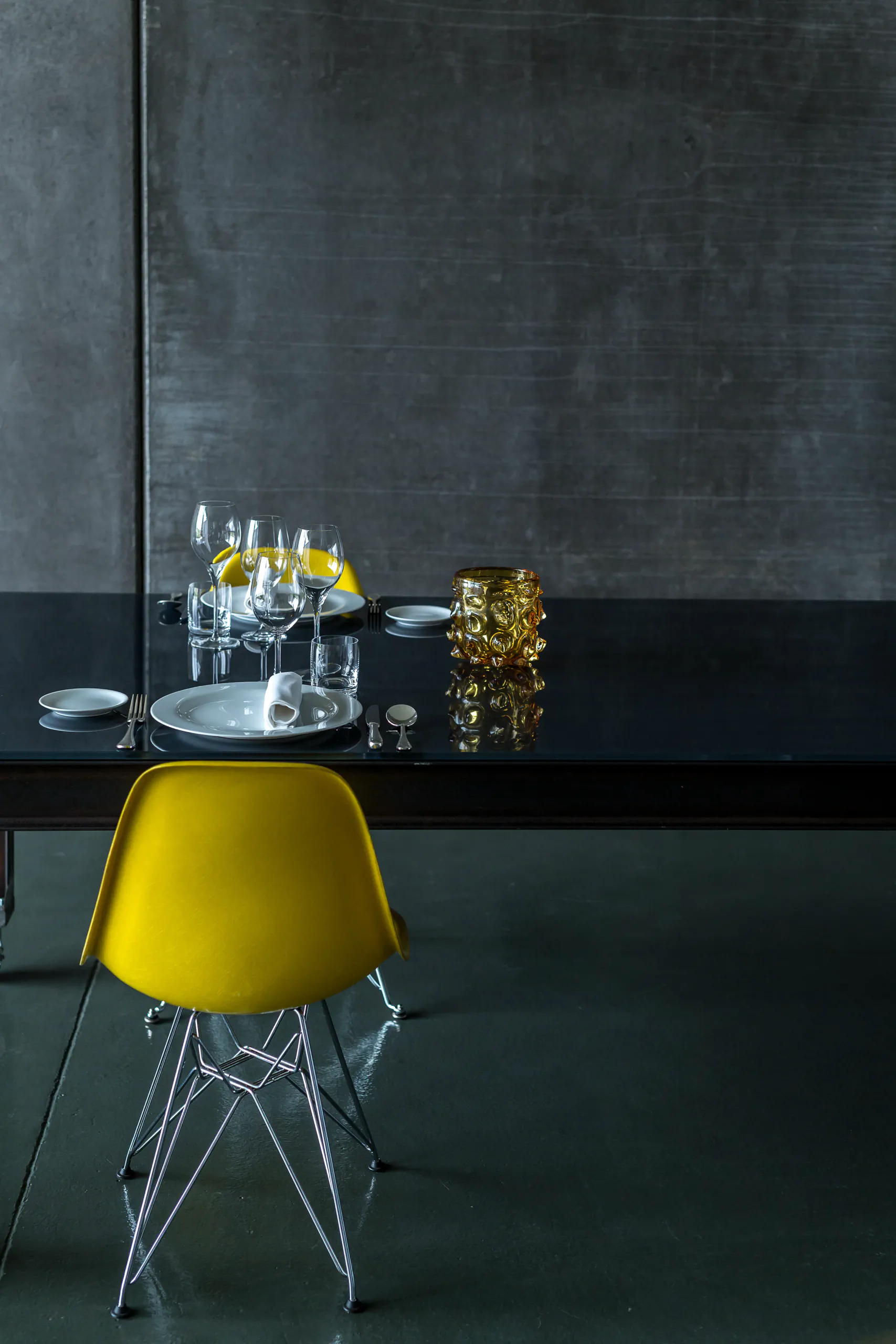Dark modern room with a marble counter and a yellow chair