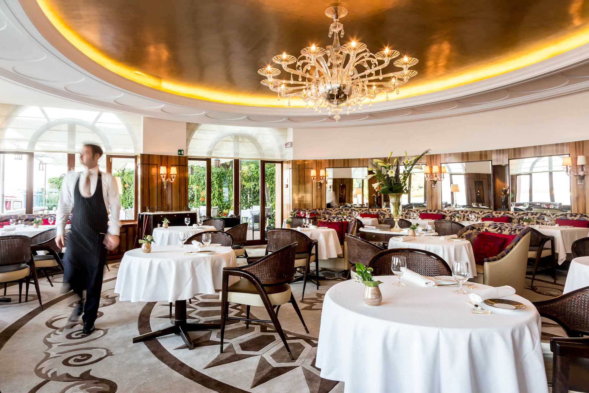 Opulent classic restaurant with a large chandelier and white-linen tables