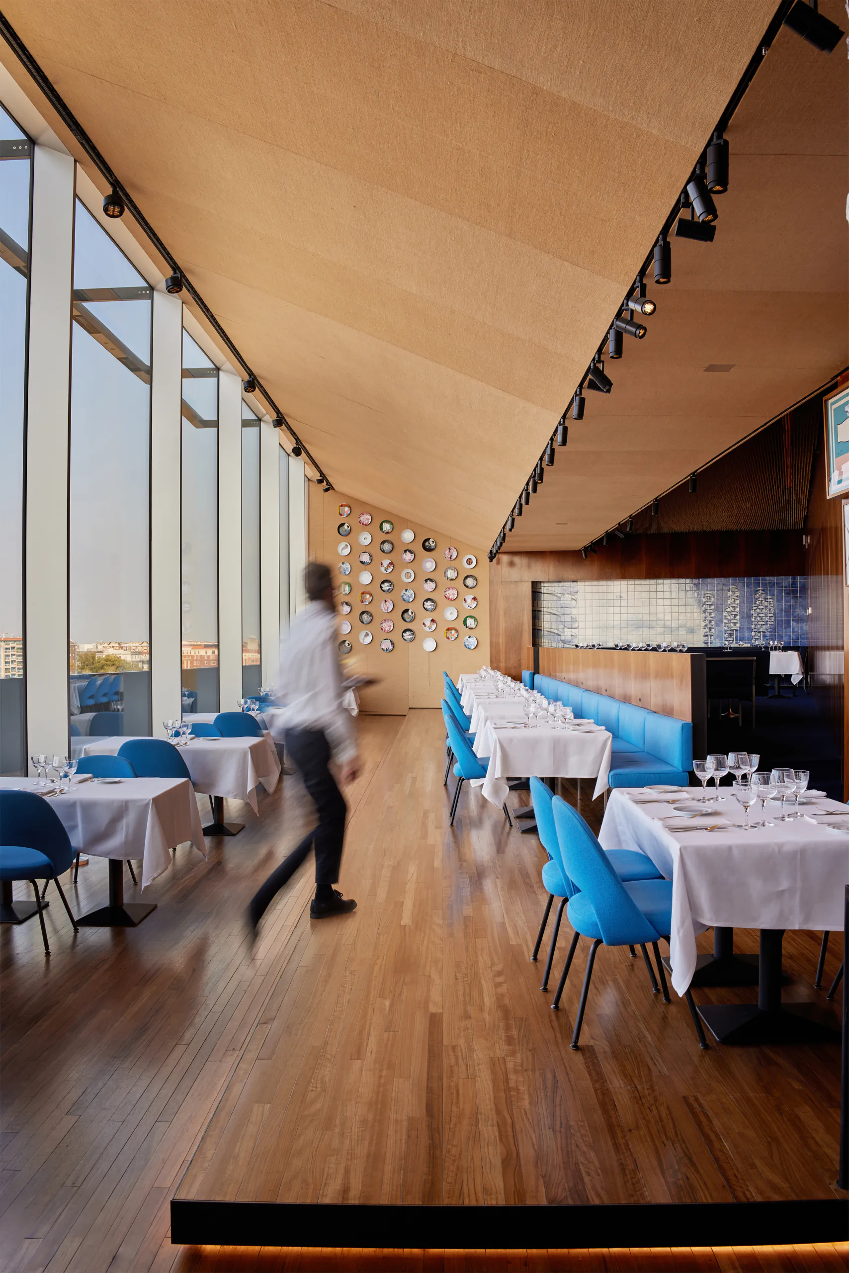 Bright modern restaurant with wood tones and blue chairs — Torre, Fondazione Prada, Milan
