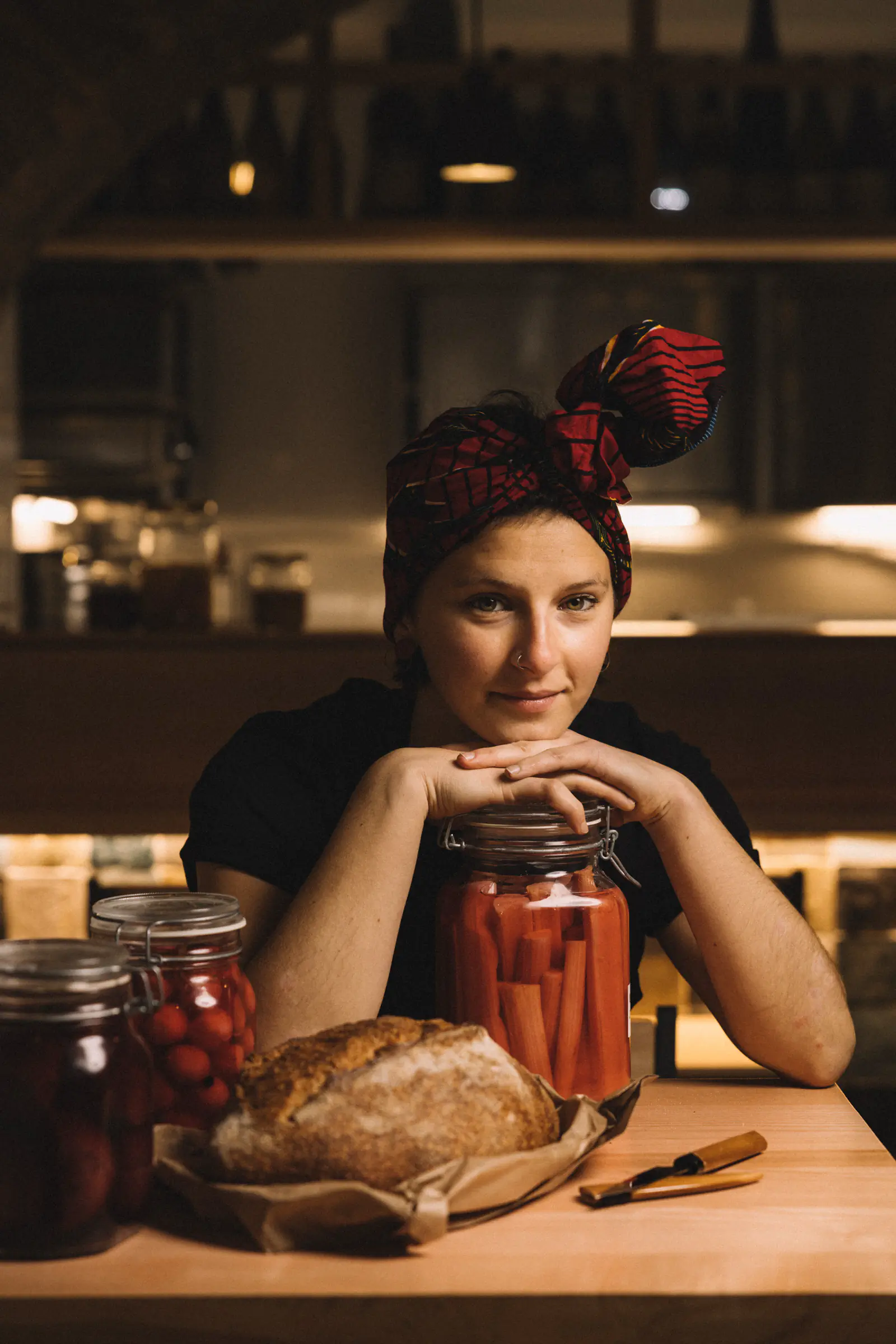 Woman with a floral hairpiece at a table with preserves and bread