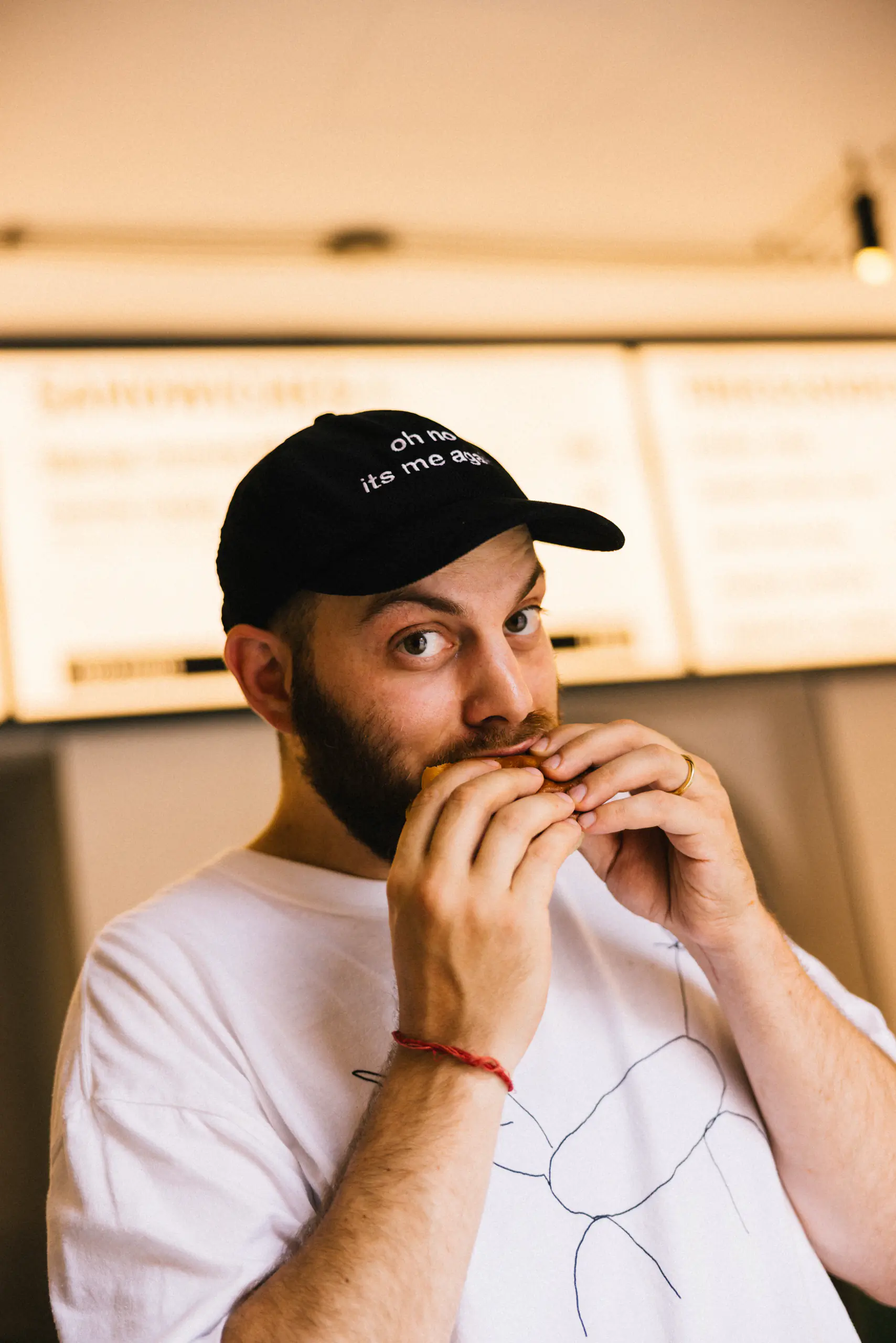 Man in a cap tasting food in a bright room