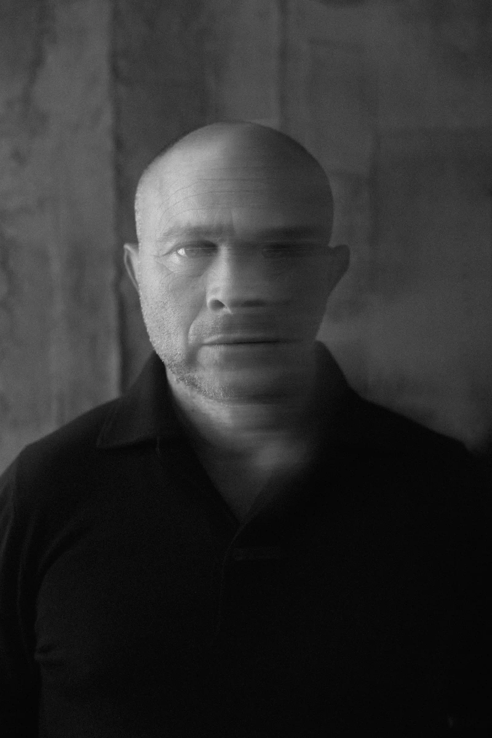 Moody dark portrait of a bald man in black