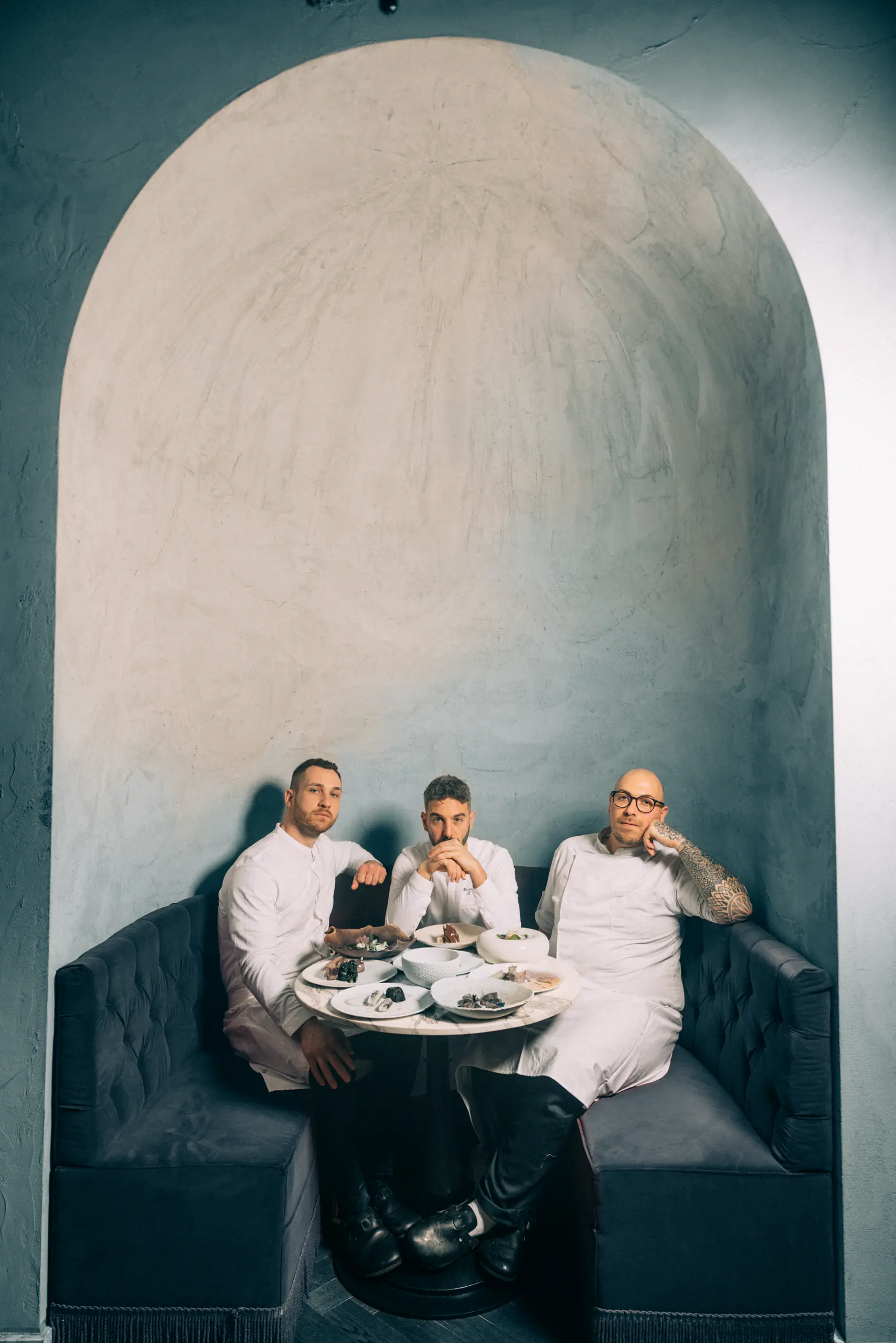 Three people seated at a small table in an alcove