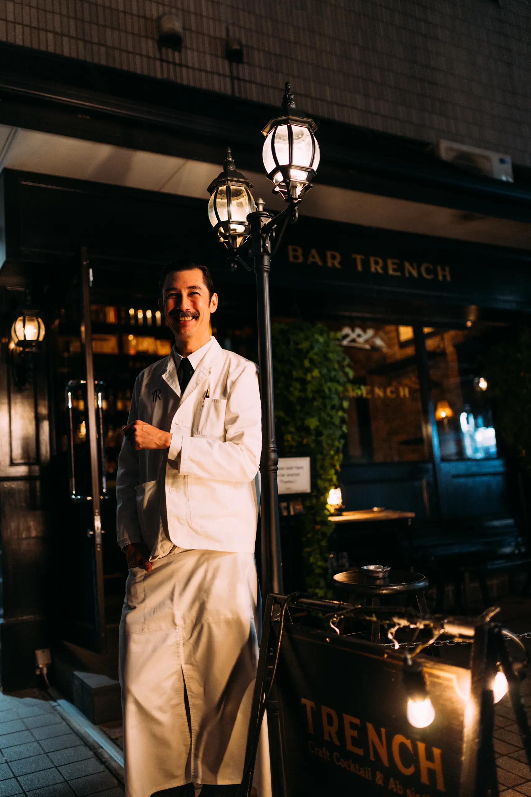 Chef in whites standing in a restaurant doorway at night