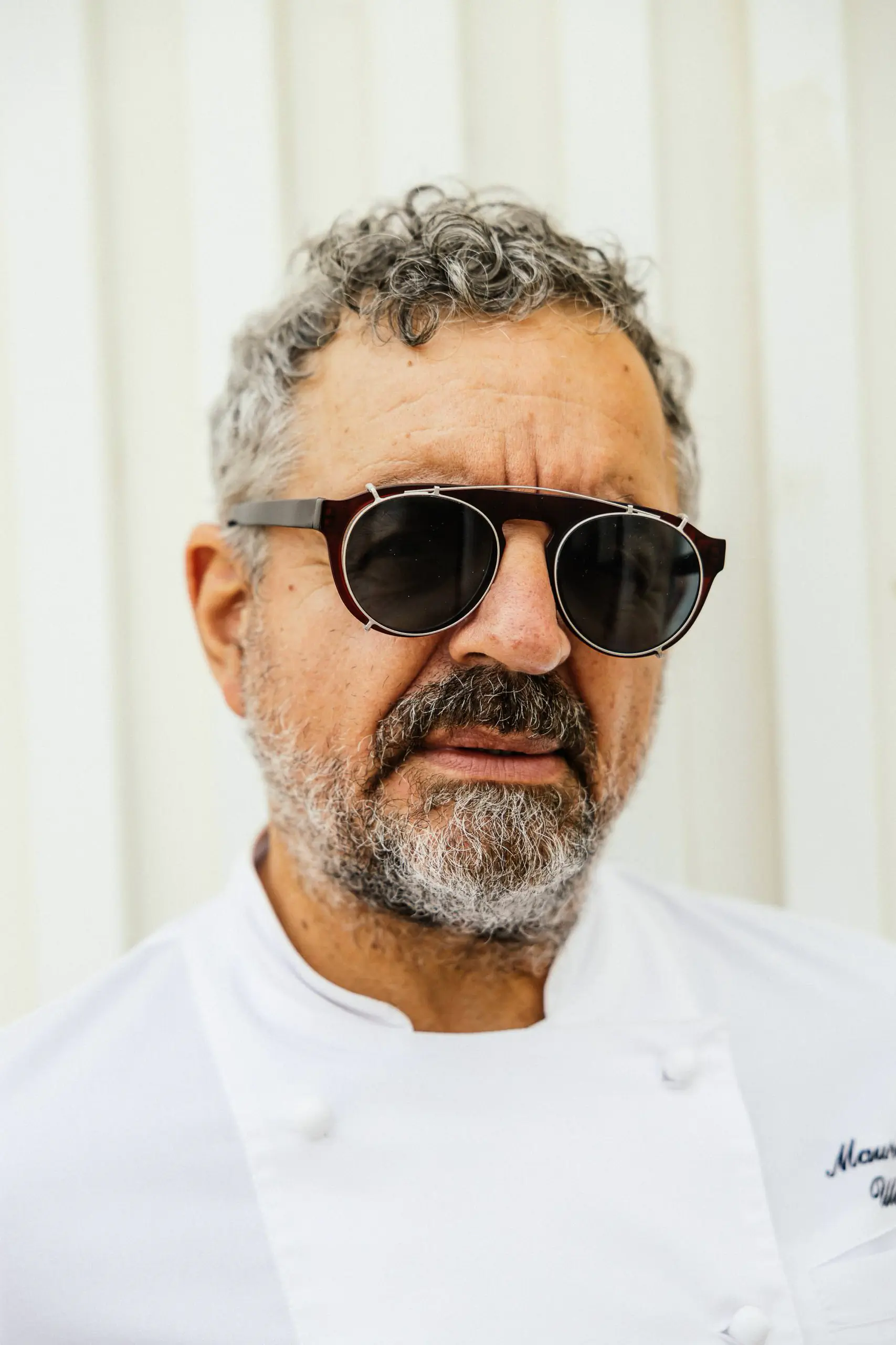 Portrait of a chef with grey curly hair and sunglasses - Mauro Uliassi