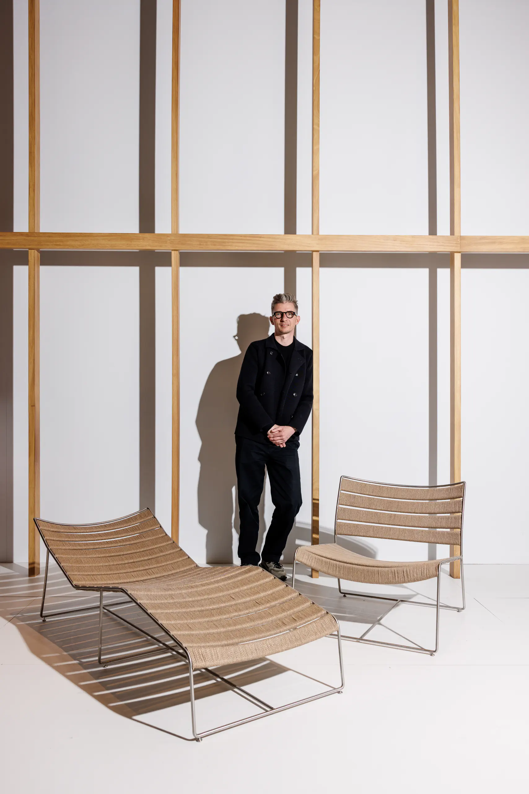 Man in black among modern chairs in a minimalist showroom