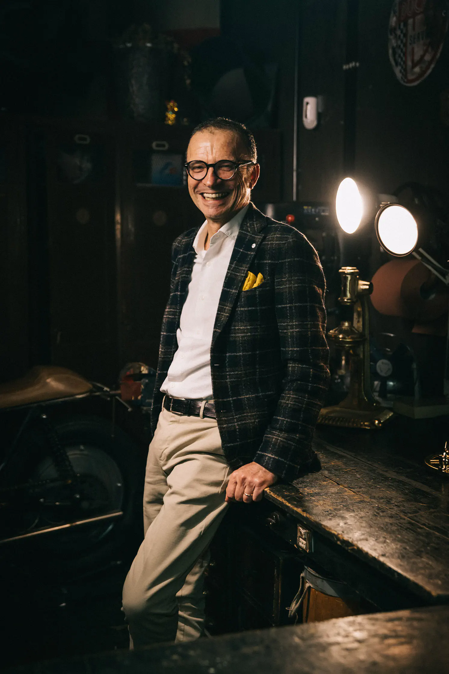 Man in a checked jacket leaning by a spotlight