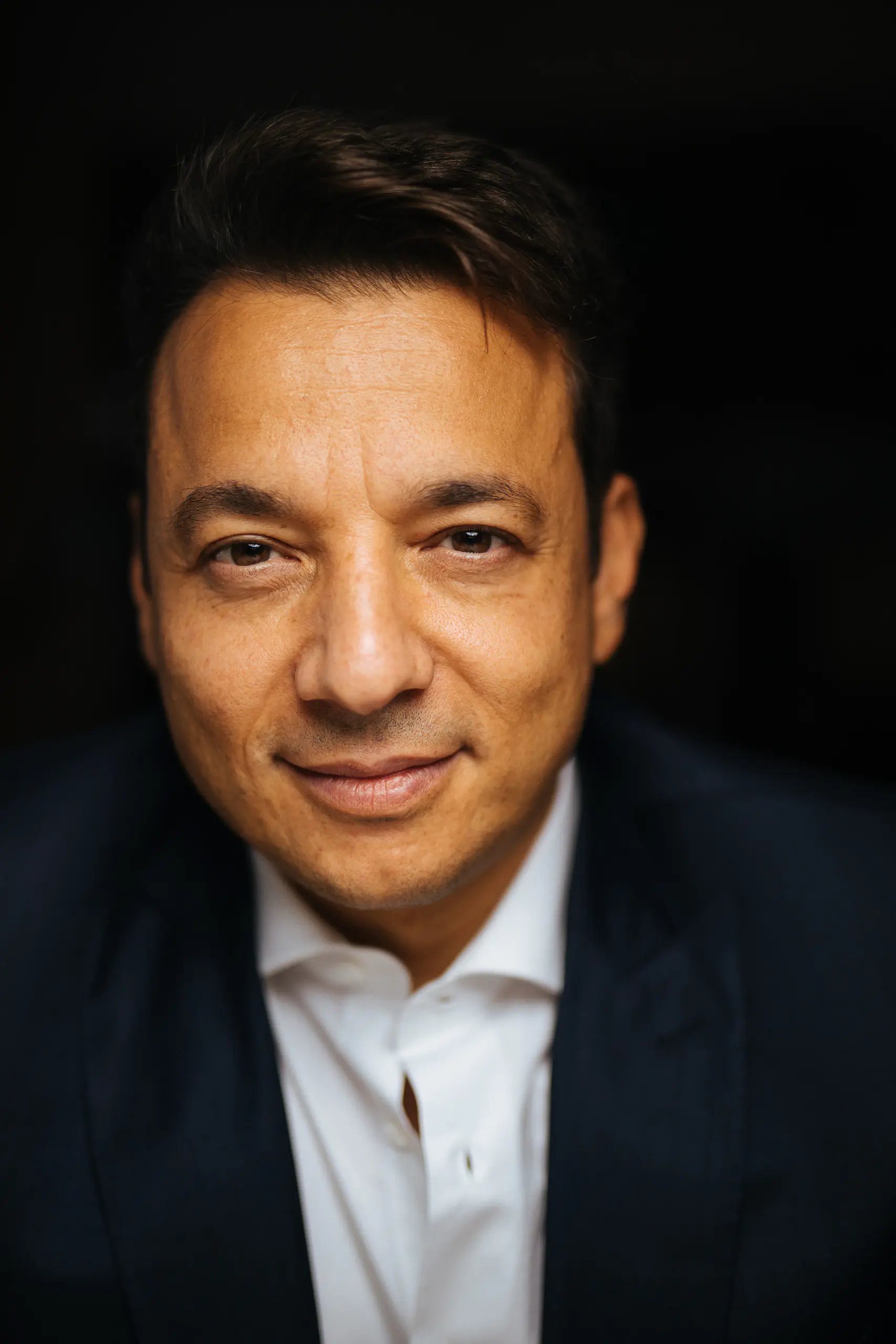 Portrait of a smiling man against a black background
