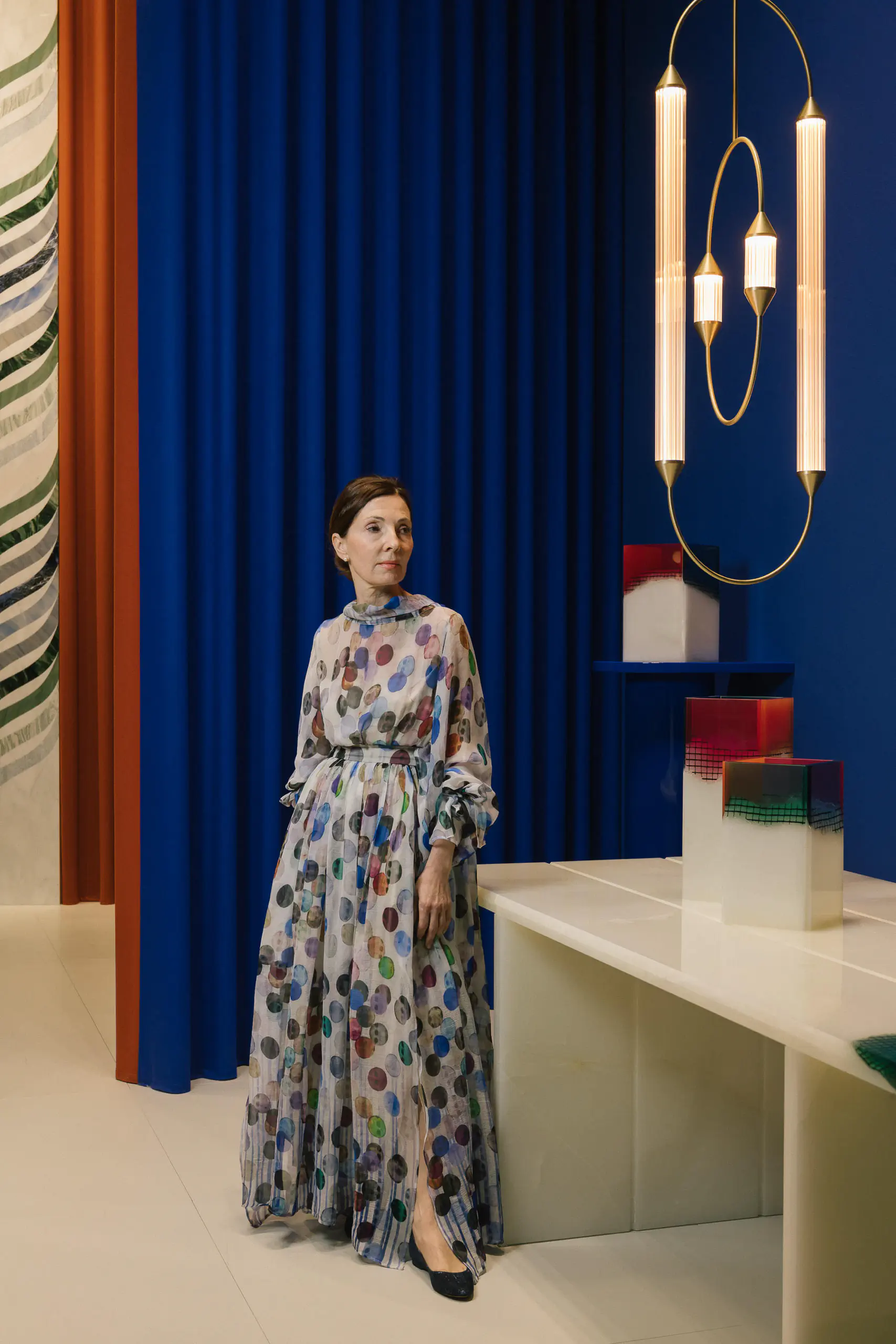 Woman in a floral gown standing in a colourful modern interior