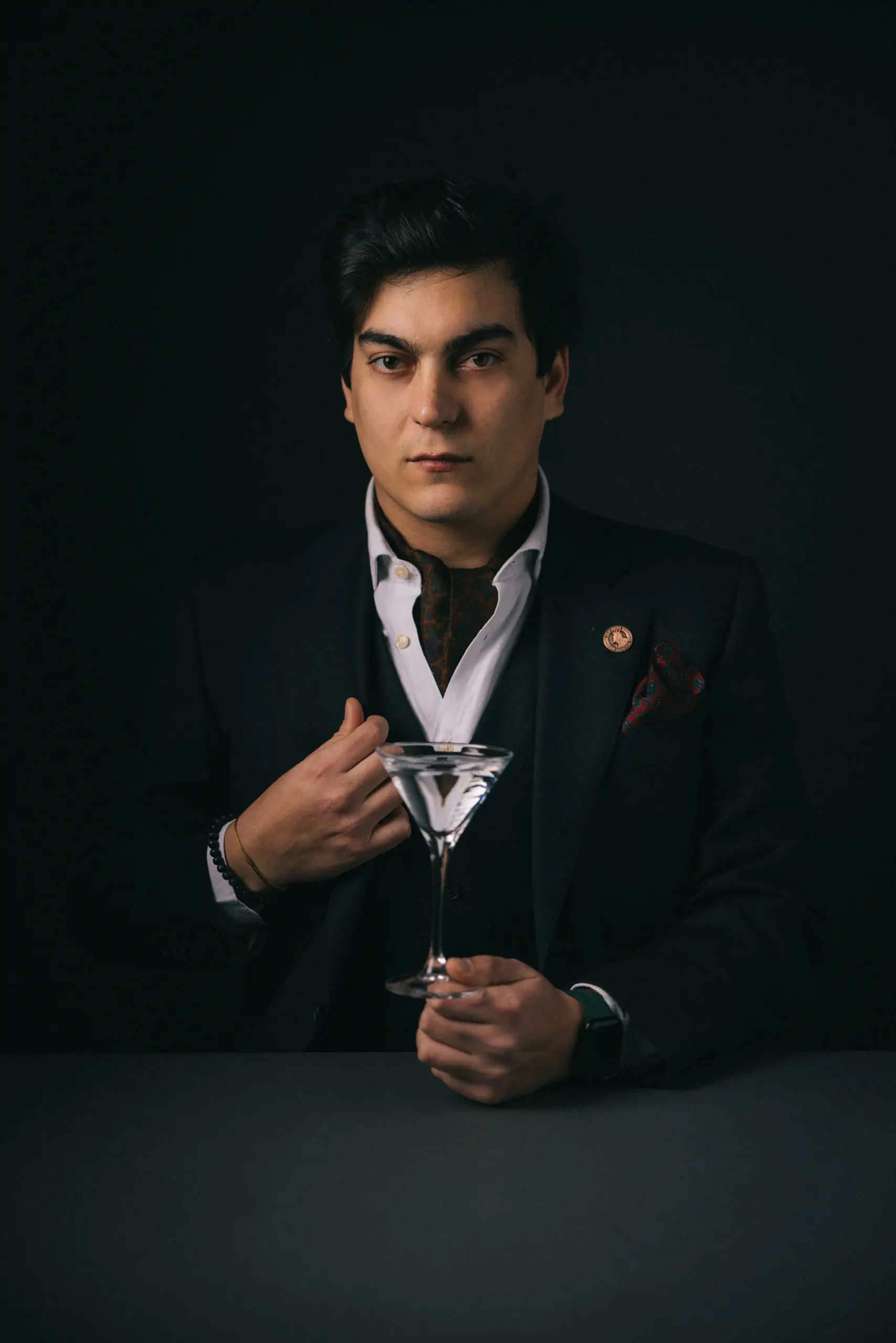 Dramatic portrait of a man in a suit adjusting his lapel