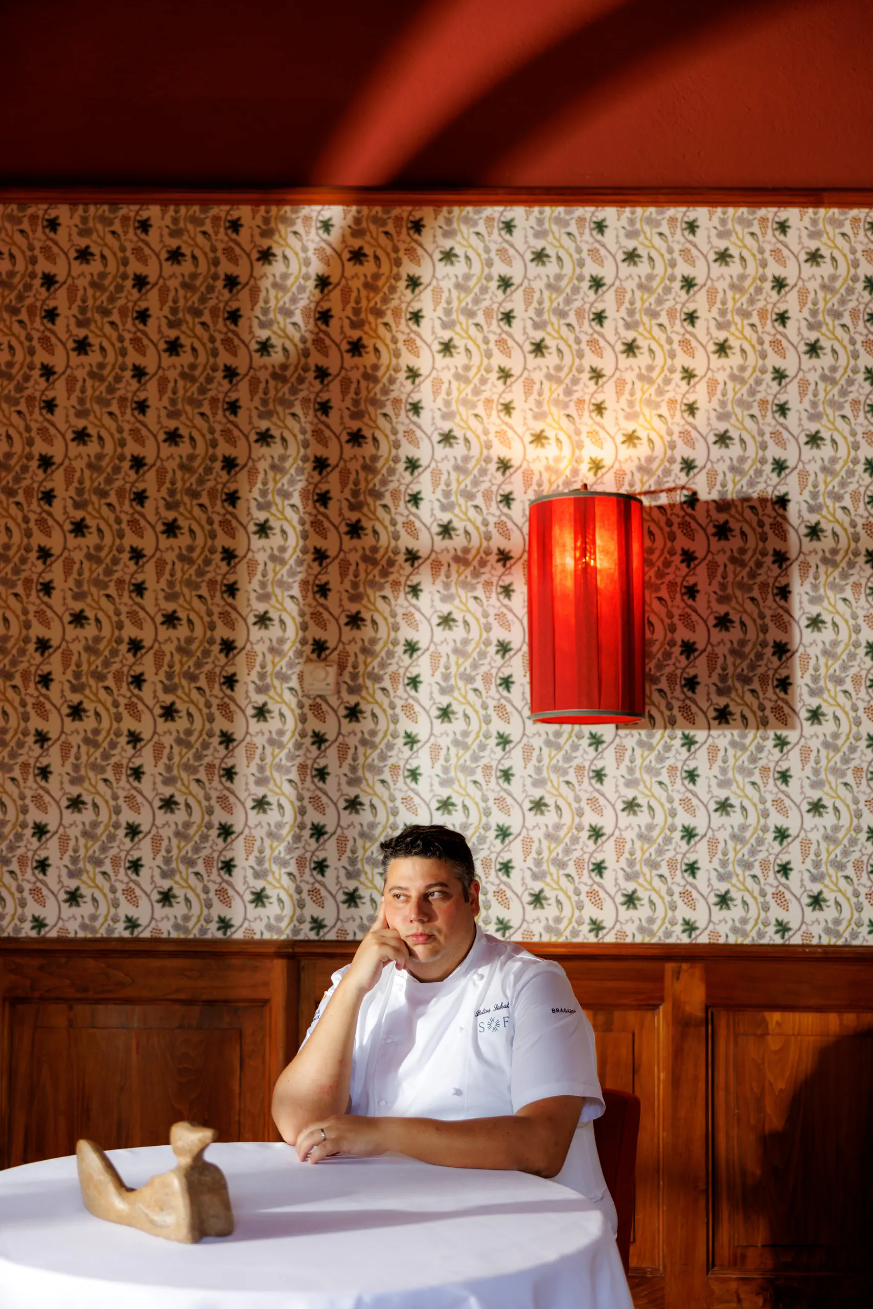 Chef seated in an elegant patterned dining room — Borgo San Felice